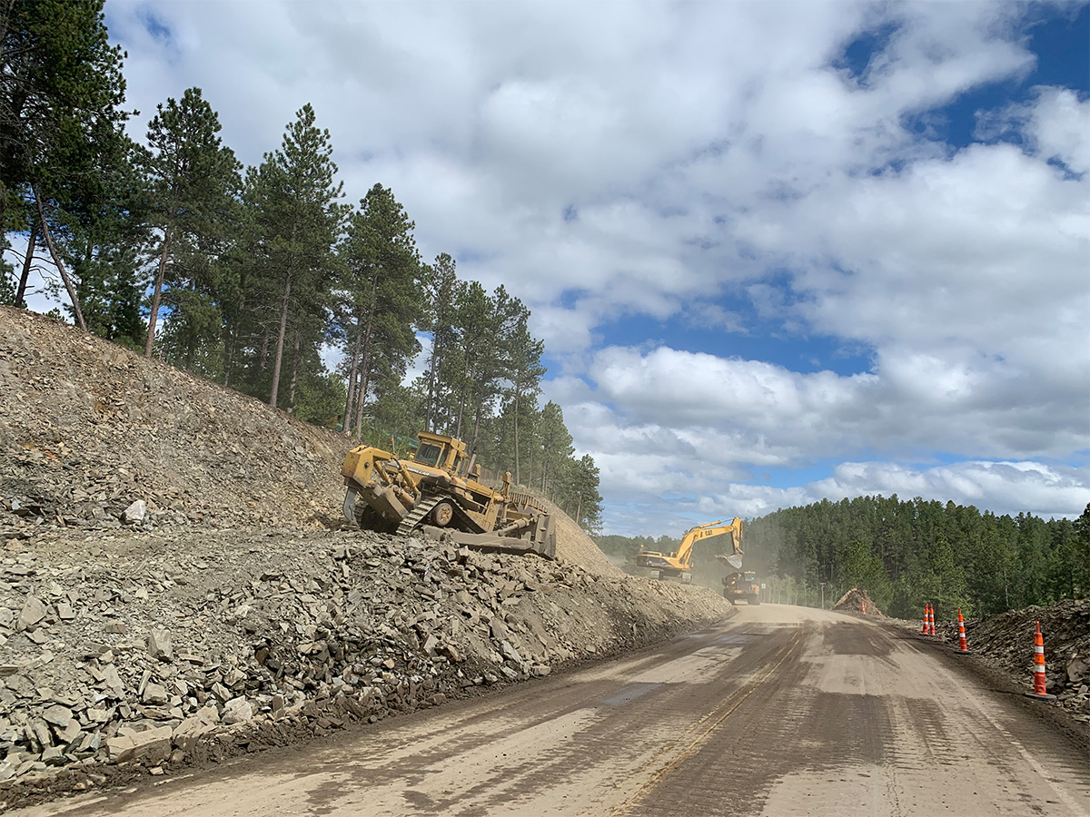 Large construction equipment grading new roadway.